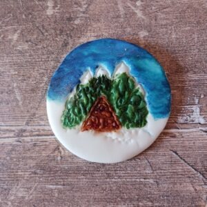 Log cabin in woods and snow biscuit stamp.
